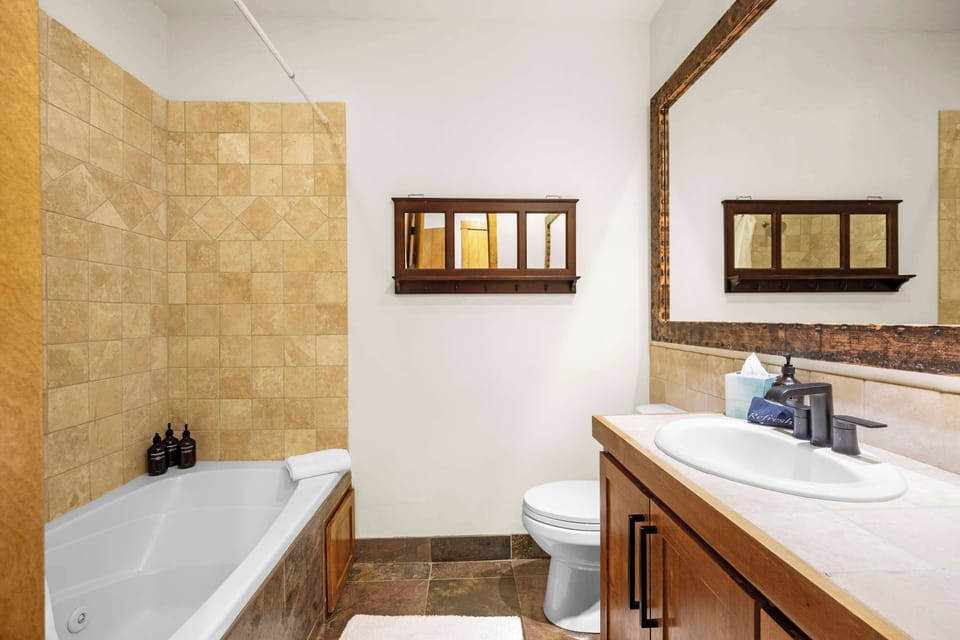 Bathroom 2 (main floor): En-suite bathroom with dual sinks, shower/tub combo
