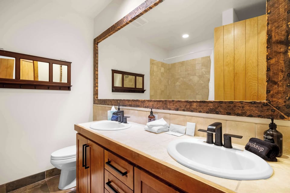 Bathroom 2 (main floor): En-suite bathroom with dual sinks, shower/tub combo
