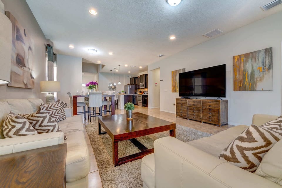 Open-concept living area with comfortable seating and a large flat-screen television