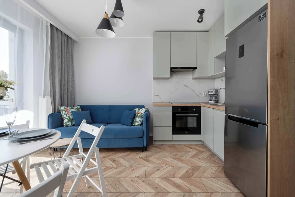Stylish kitchen and dining area with minimal white design and natural light.