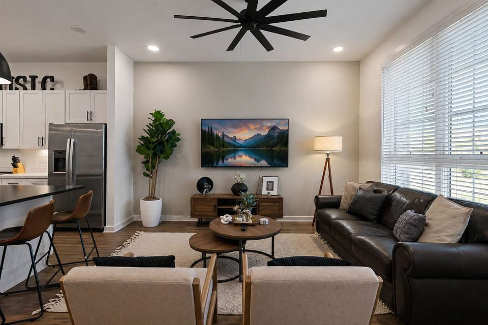 Stylish, clutter-free living room with mounted TV and leather seating.