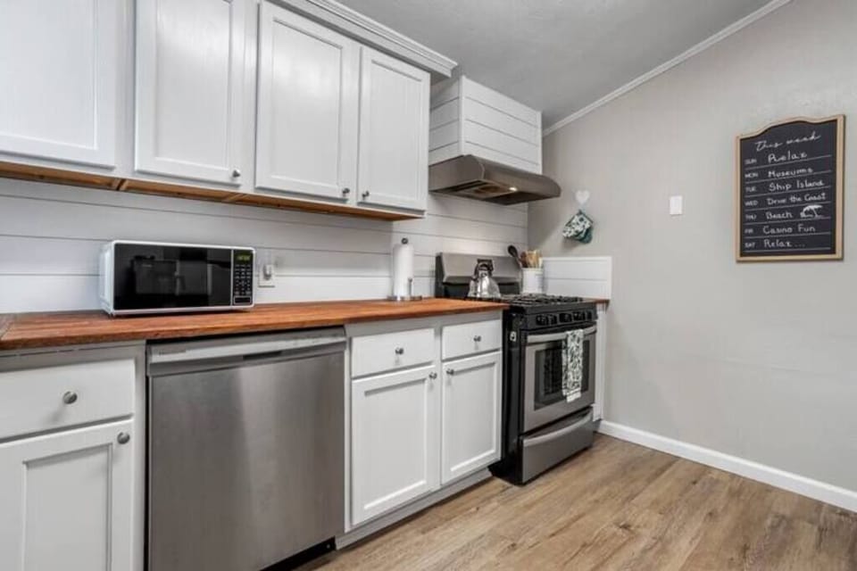 The fully equipped kitchen features modern appliances, a charming wooden counter, and a convenient layout, perfect for whipping up meals during your beach getaway.