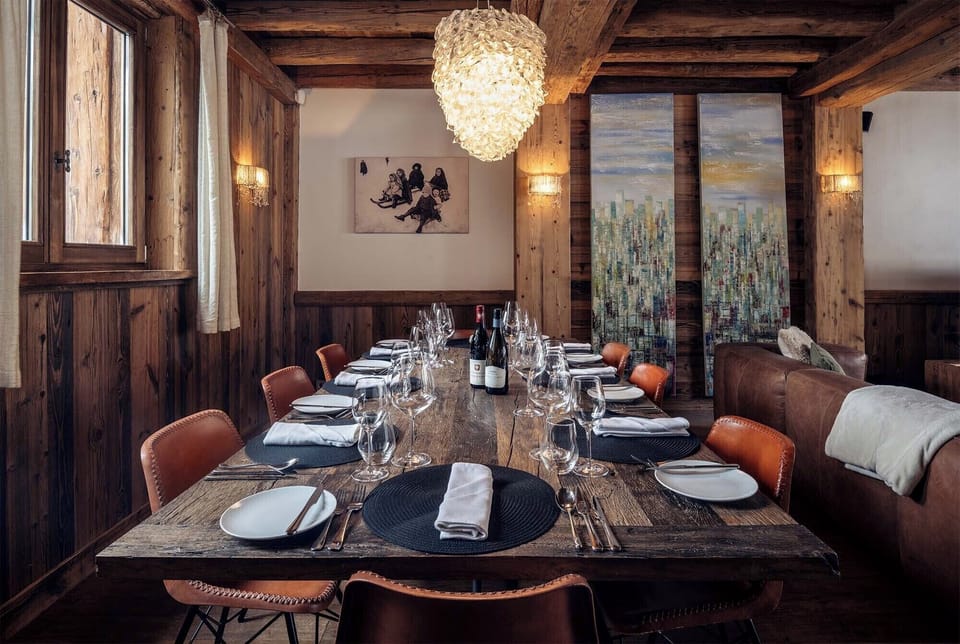 Gather your friends and family around the expansive dining table, elegantly adorned for memorable meals amidst the cozy and chic alpine atmosphere of Chalet Genepy.