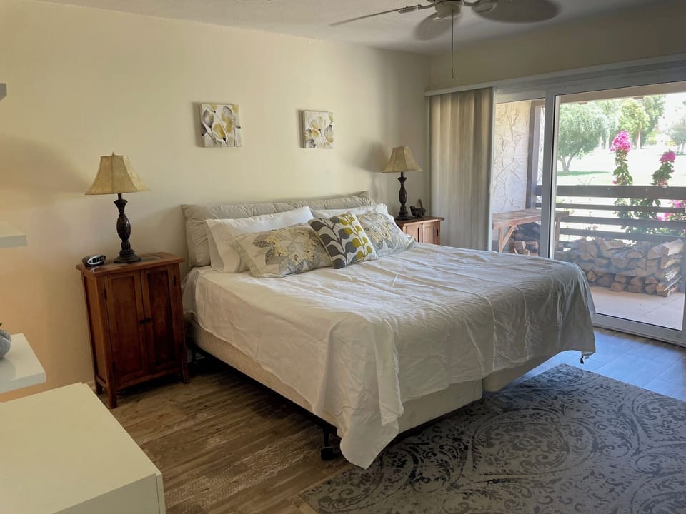 spacious primary bedroom with a king size bed, chest of drawers and tv