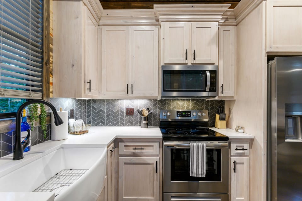Modern kitchen with chevron backsplash and stainless appliances.