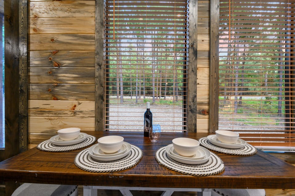 Rustic cabin dining table set for four with forest view.