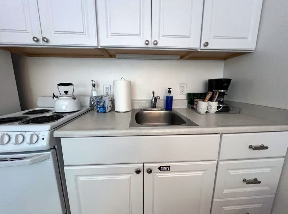 A spotless and efficient kitchenette fully stocked for simple meal prep and everyday convenience.