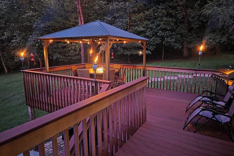 Lighted deck, conversation table fire pit, grill, lounge chairs, tiki torches