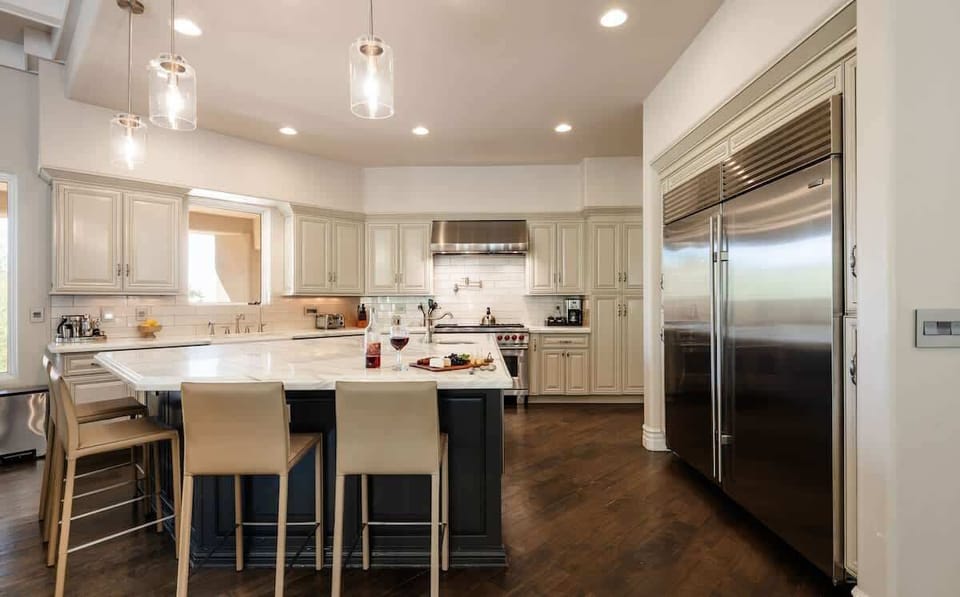 Fully equipped kitchen with stainless steal appliances, mini wine cooler, ice maker, and a kitchen island with bar seating for 4 guests.
