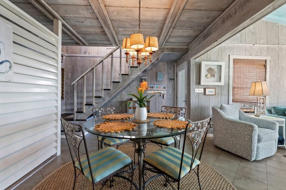 Cozy dining nook with warm lighting where you'll enjoy meals beneath rustic beamed ceilings and coastal-inspired décor.