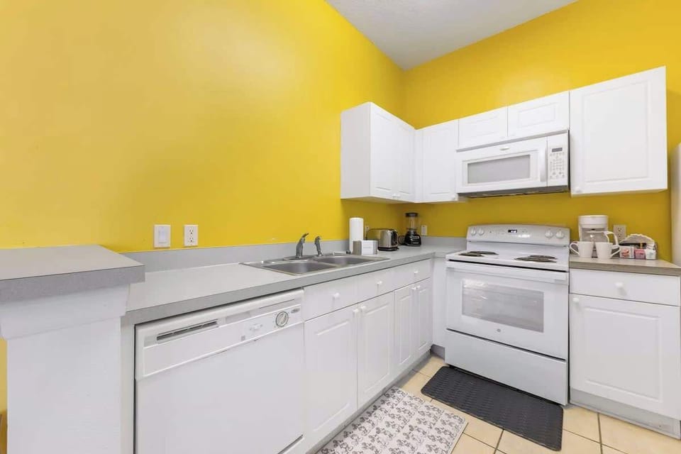 Modern kitchen featuring a stove, oven, microwave, dishwasher, refrigerator, and coffee maker, along with all the essential cookware and utensils—perfect for preparing meals and snacks during your stay.