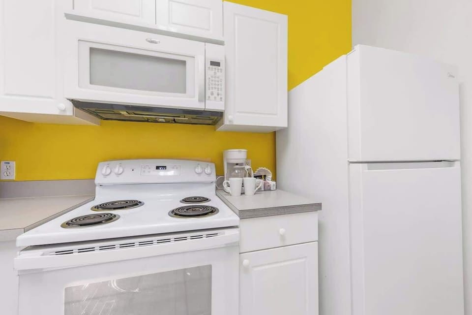 The kitchen features a four-burner stove, oven, and modern appliances—perfect for preparing anything from quick breakfasts to full family dinners, offering all the essentials for convenient home-style cooking.