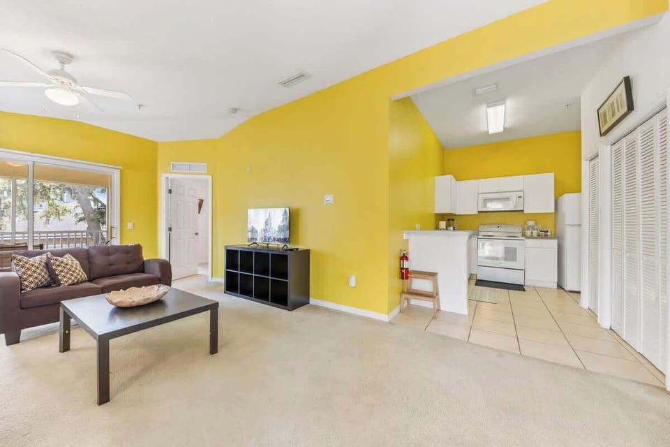 From this angle, the open-concept living room flows into the fully equipped kitchen, letting you relax on the sofa while staying connected to dining and cooking areas—an ideal setup for family gatherings and entertaining.