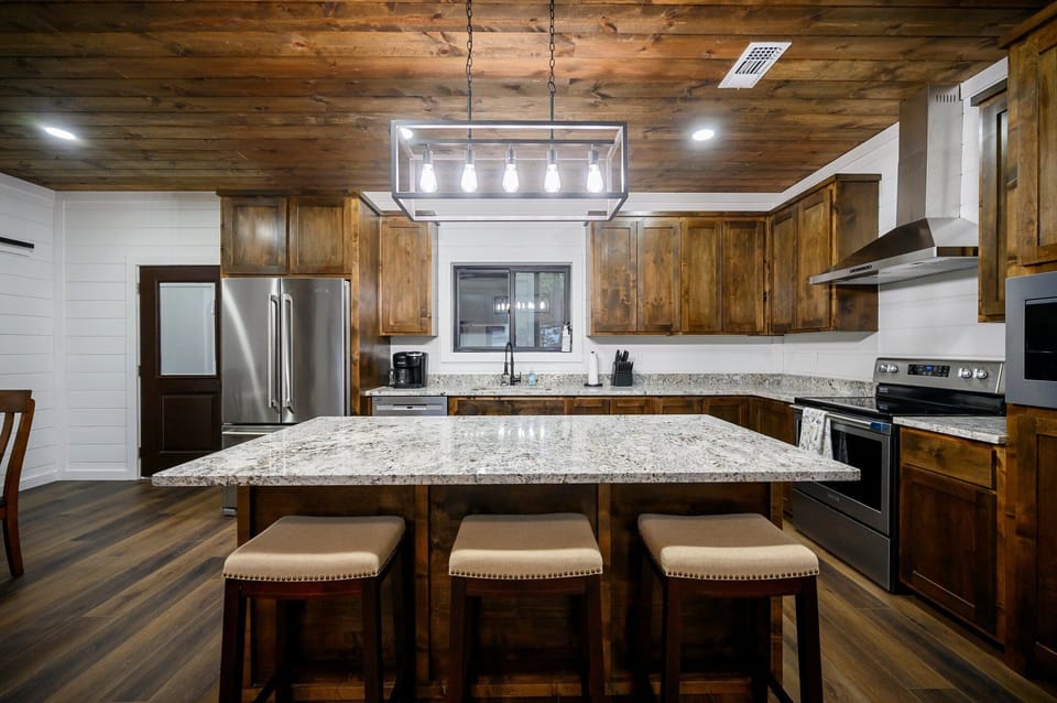 Modern kitchen w/ island & stainless appliances—inviting, chef-ready space.