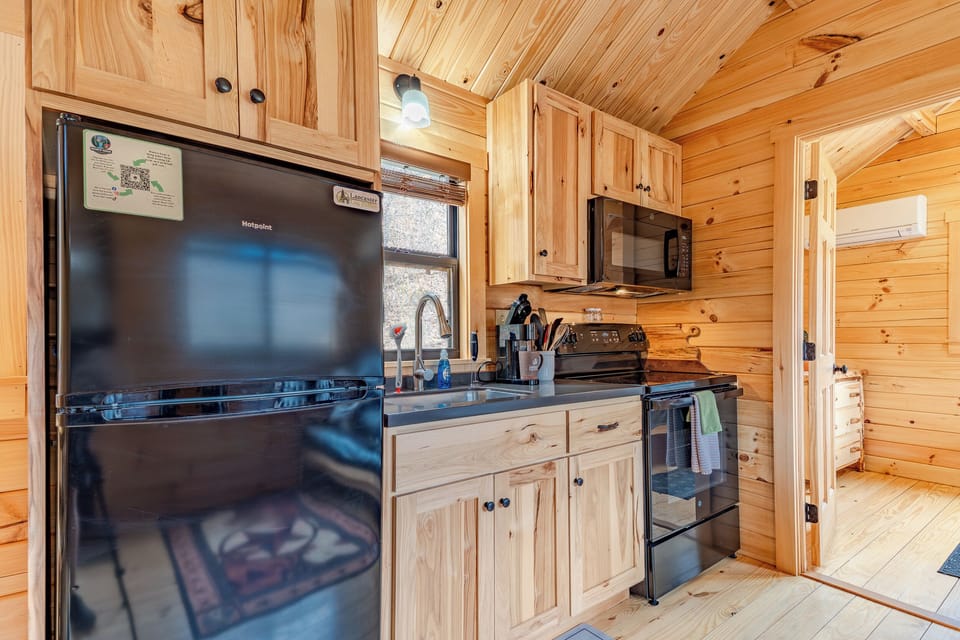 Kitchenette area with a fridge, freezer, microwave, oven, Keurig, sink and kitchenware. Perfect for cooking all types of meals!