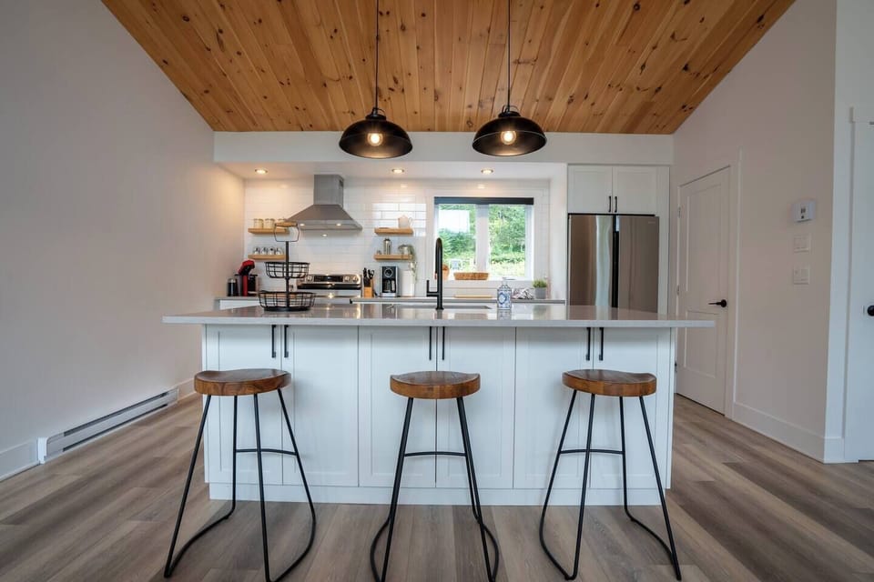Cuisine très bien équipée, îlot au centre, grand garde-manger, 3 tabourets, vue sur la pièce / Very well equipped kitchen, island in the center, large pantry, 3 stools, view of the room (1)