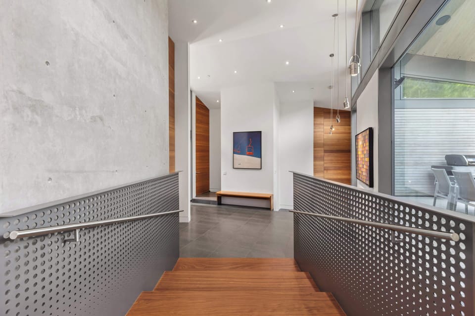 - Contemporary hallway with sleek perforated railing  
- Natural light and art create a gallery-like feel  
- Effortless transition from indoors to outdoor deck  