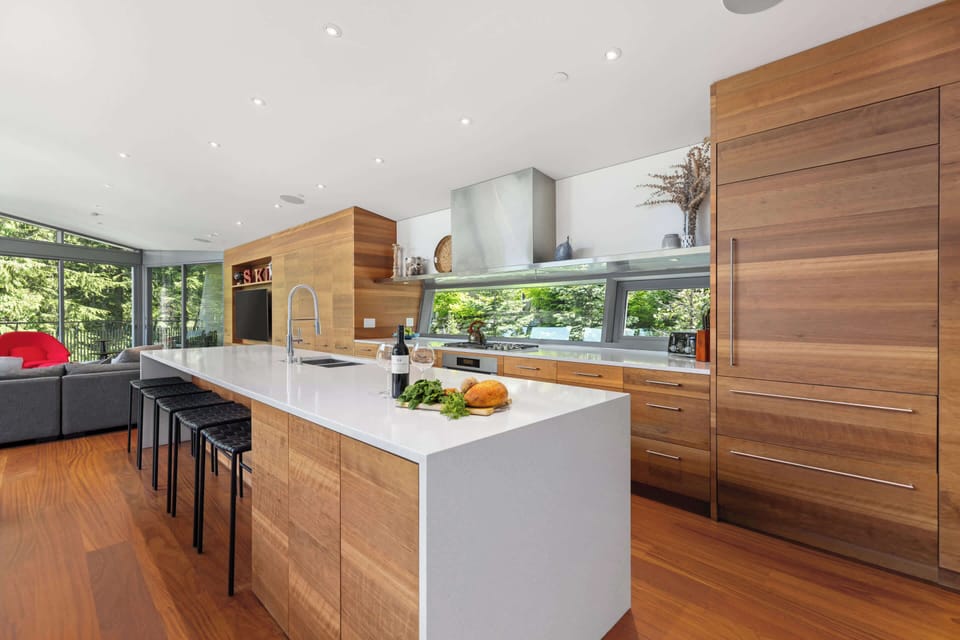 - Contemporary kitchen with wood cabinetry and long island  
- Fully equipped for gourmet cooking and group meals  
- Open layout connects seamlessly with living area  
