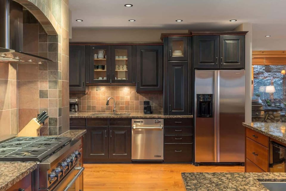 Well-equipped kitchen w/ ample cabinetry, stone backsplash, and clear workspace for shared cooking