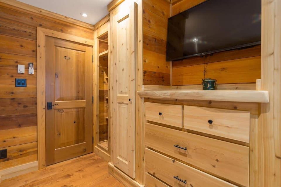 Neat bedroom storage w/ dresser, closet space, and a wall-mounted TV