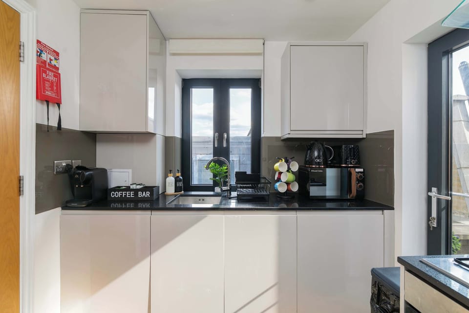 Sleek, modern kitchen with oven, hob and coffee bar, ideal for home-cooked dinners