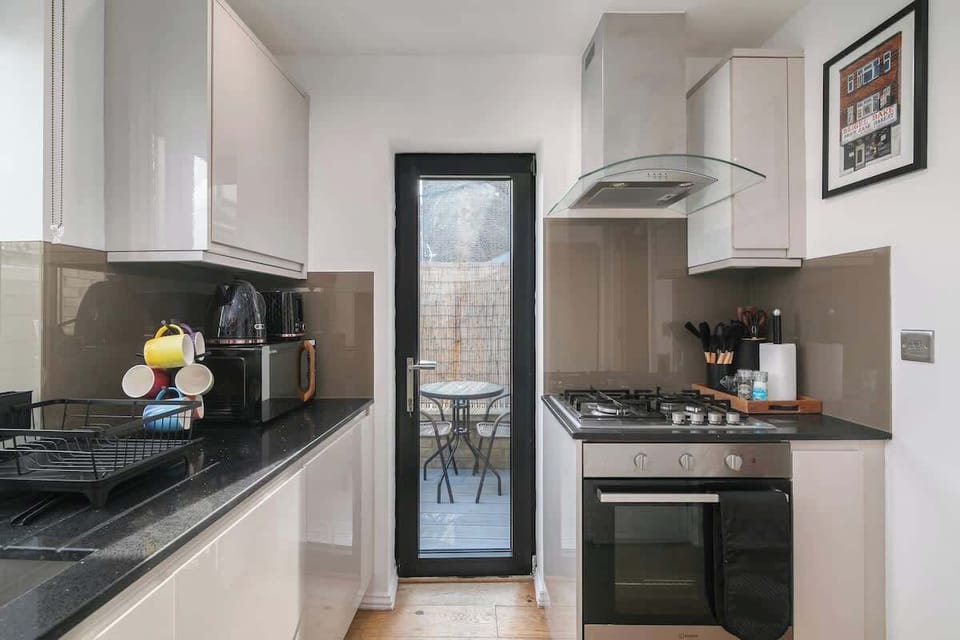 Stylish modern kitchen featuring oven, hob and a dedicated coffee bar, fully equipped for comfortable stays with complimentary coffee and tea.