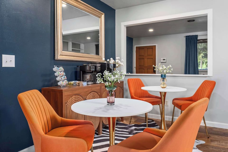 Cozy dining nook with orange accent chairs—perfect for morning coffee or intimate meals.