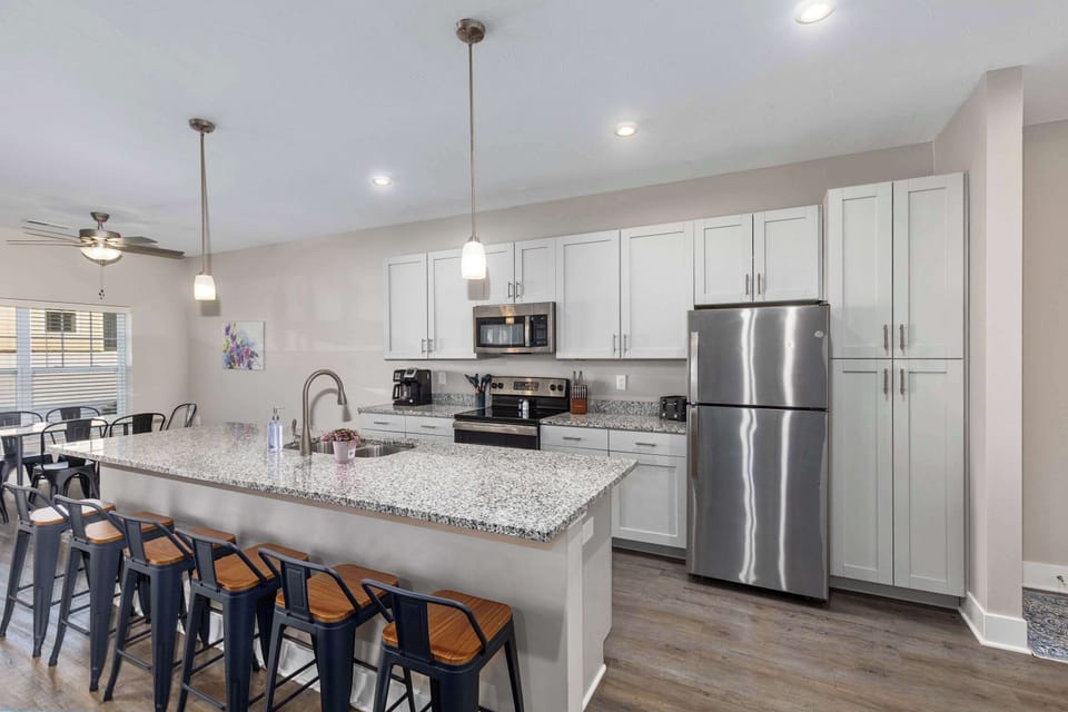 Bright, fully equipped kitchen with a spacious island bar — perfect for cooking, gathering, or enjoying your morning coffee.