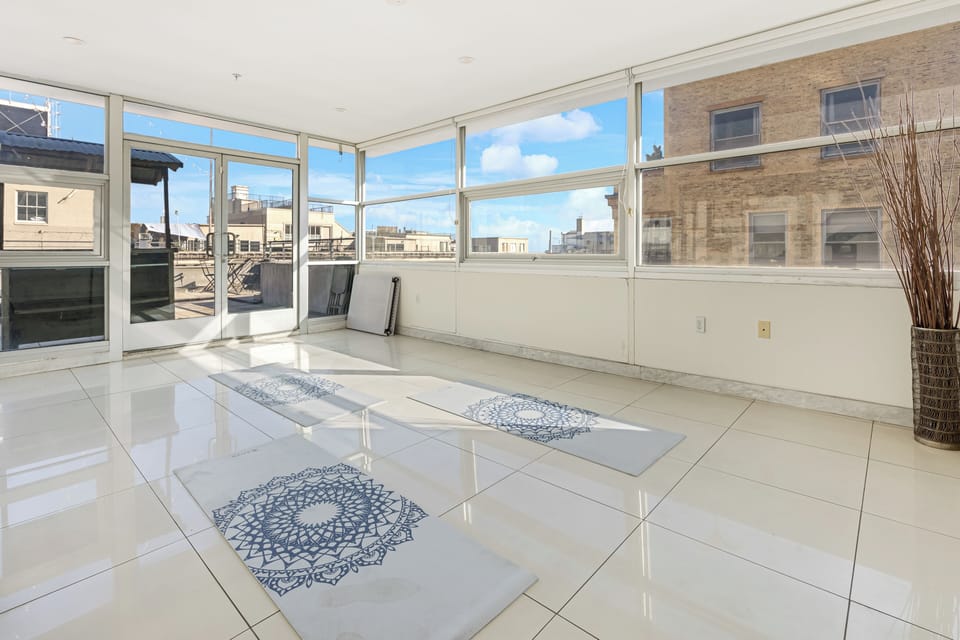 A sunlit room with floor-to-ceiling windows.