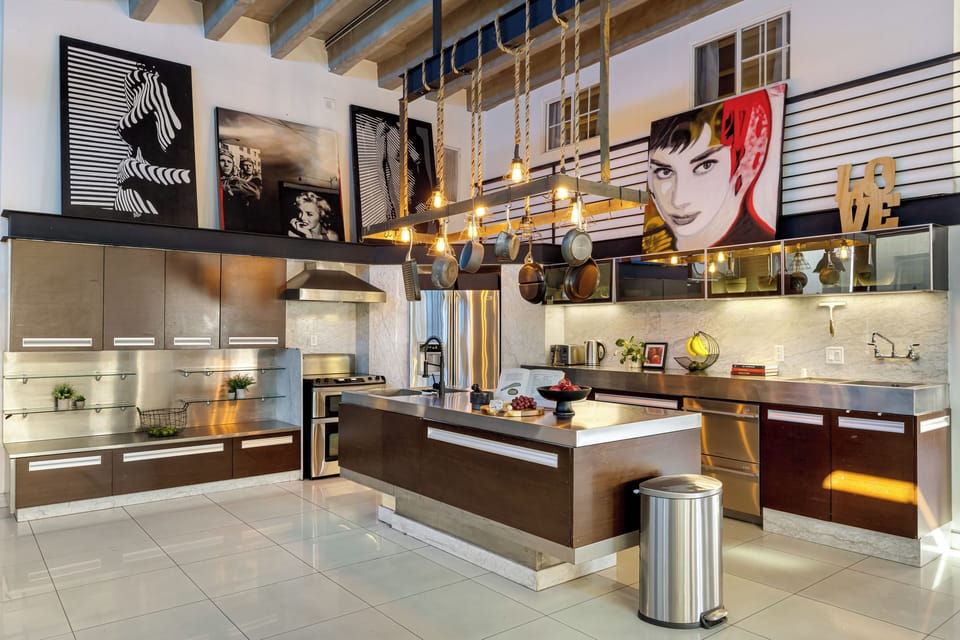 A modern kitchen with stainless steel appliances and unique art pieces creates a stylish and functional culinary space.