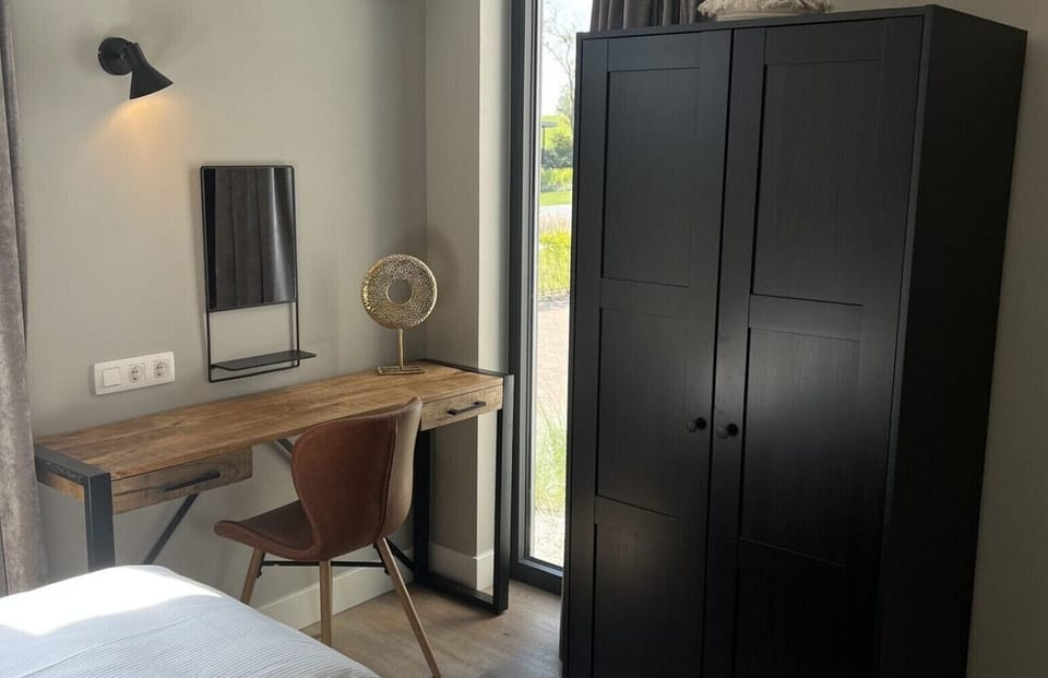 Bedroom with desk and wardrobe at Vakantiepark de Zeeuwse Parel - de Zeebries