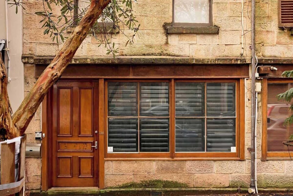 Beautiful heritage sandstone building at 138 Cathedral Street. Classic Woolloomooloo architecture with timber features and traditional louvered windows in historic streetscape.