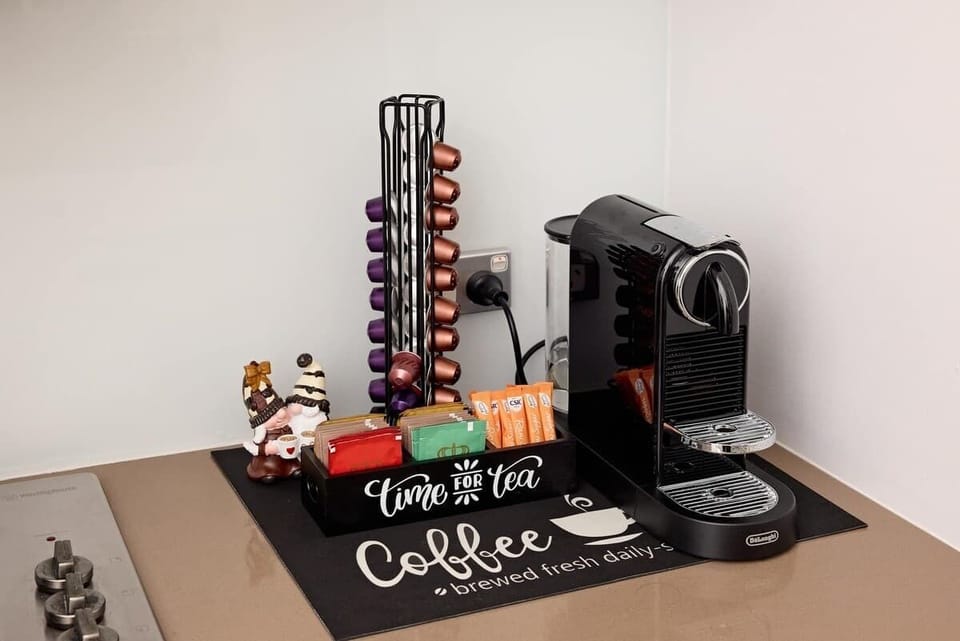 Premium coffee station with Nespresso machine, variety of pods and tea selection. Complete with capsule holder and festive touches for perfect morning brew in your heritage home.