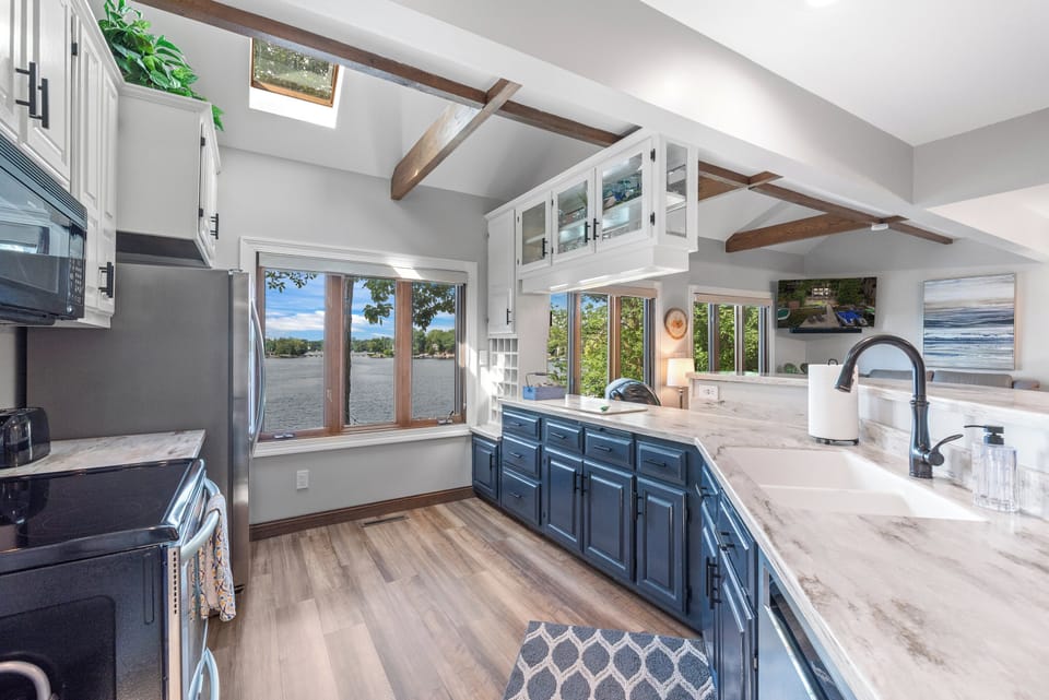 Kitchen with wide windows offering a beautiful lake backdrop.

