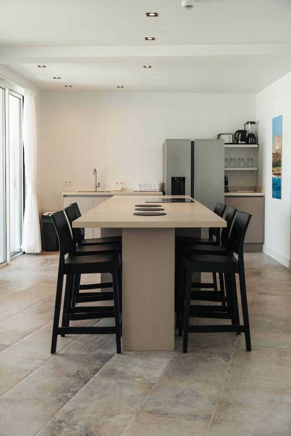 Gather the group for a meal or morning coffee at this stylish kitchen island, where minimalist design meets functional comfort in the heart of the open-concept living space.