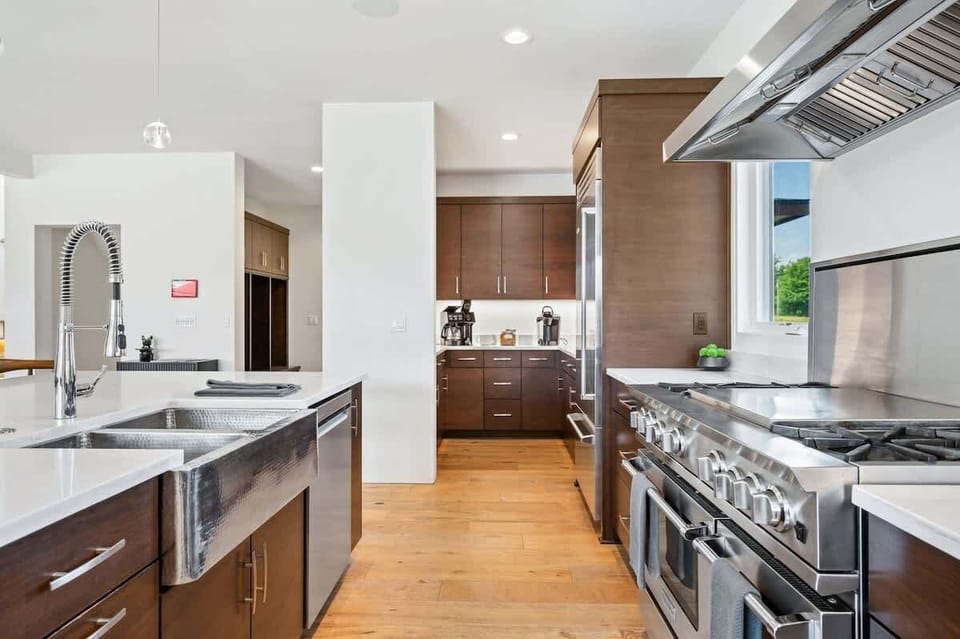 A well-appointed chef’s kitchen awaits, featuring a coffee bar, pantry, and adjacent mudroom with laundry.