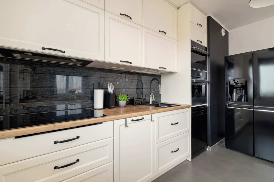 A wide kitchen and dining area with wooden furniture, pendant lamps, and spacious design.
