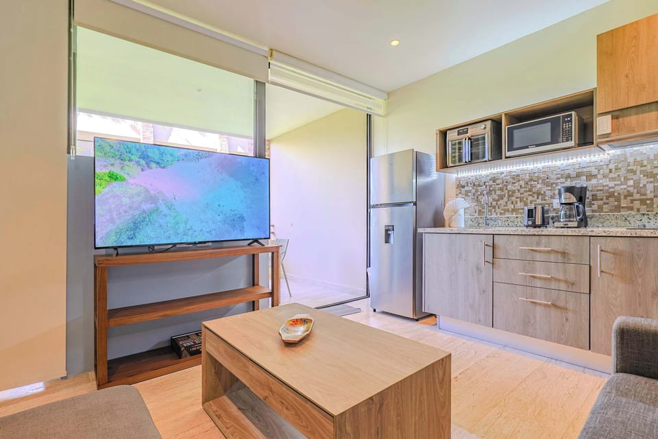 Open-concept living with a well-equipped kitchen and flat-screen TV.