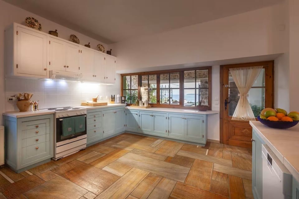 Fully stocked kitchen looking out towards covered patio/barbecue/breakfast area.