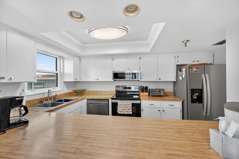 Sleek kitchen w/ stainless appliances, bright counters & a clean, modern layout.
