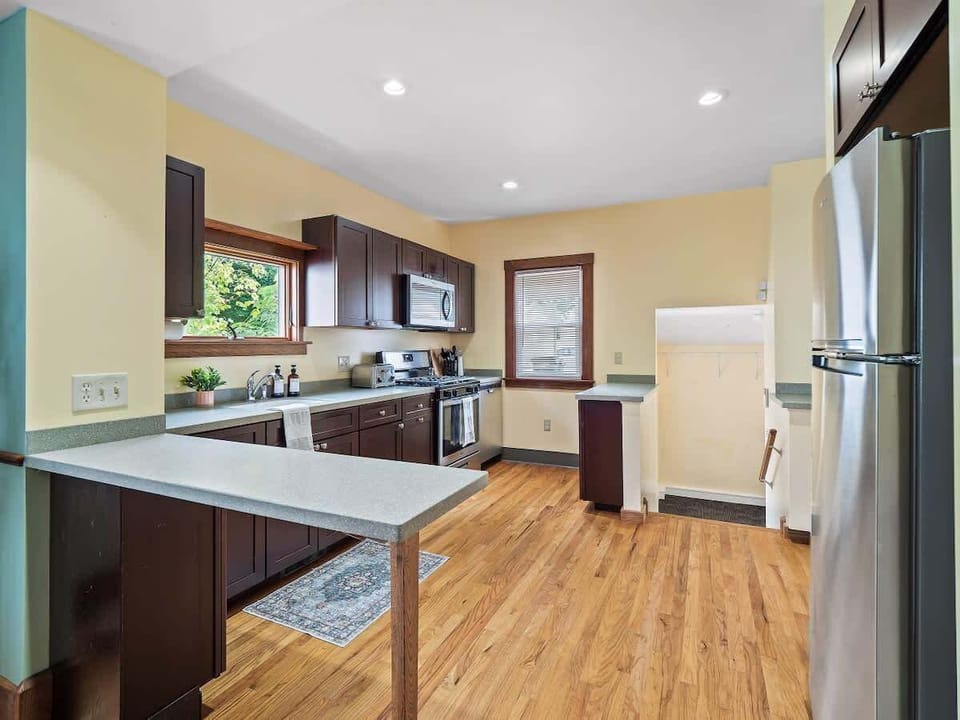 Bright kitchen with stainless steel appliances, lots of counter space & natural light ✨