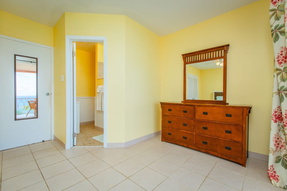 The primary suite features a large dresser,  en suite, and access to balcony.