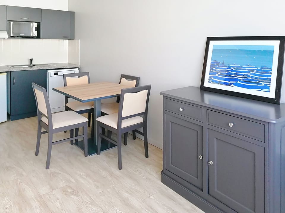 Dining area with sideboard and framed artwork, part of the open plan living space.