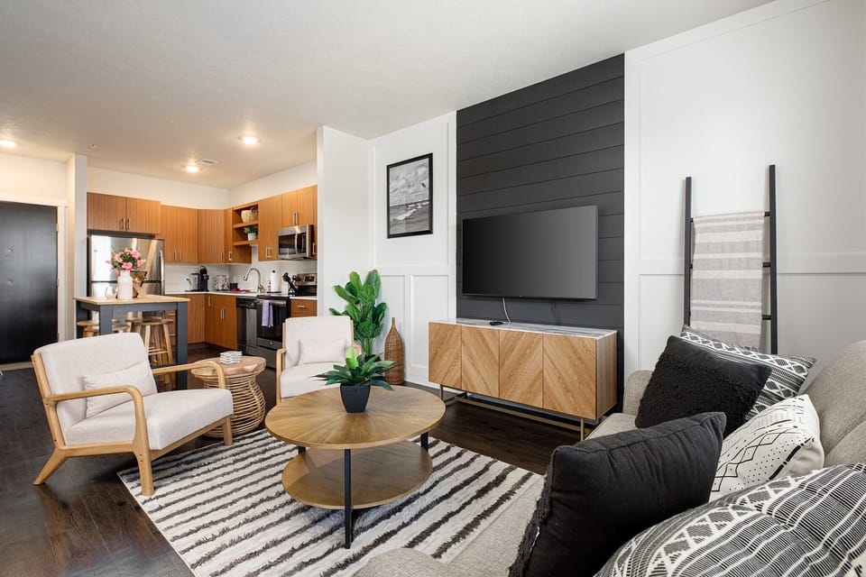 Open-concept lounge w/ modern decor, comfy sofa & seamless flow into the kitchen