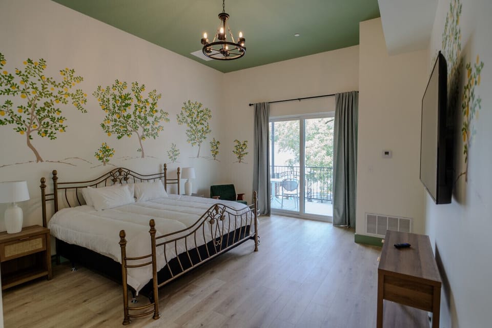 Bright and airy king room with private balcony and cheerful mural accents