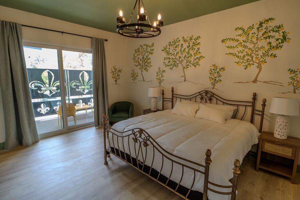 Features a King bed, hand-painted mural, and cozy finishes with balcony access