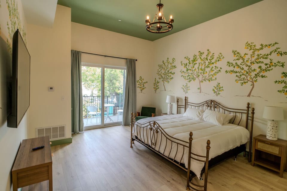 Bright and airy king room with private balcony and cheerful mural accents