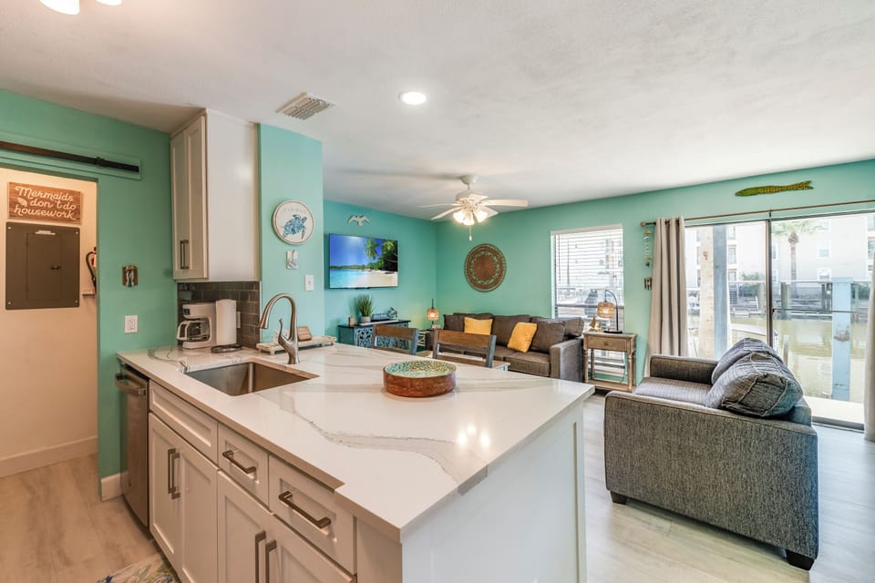 Step into your beach-inspired retreat where the open kitchen flows into a cozy living area, perfect for gathering with loved ones after sandy adventures.