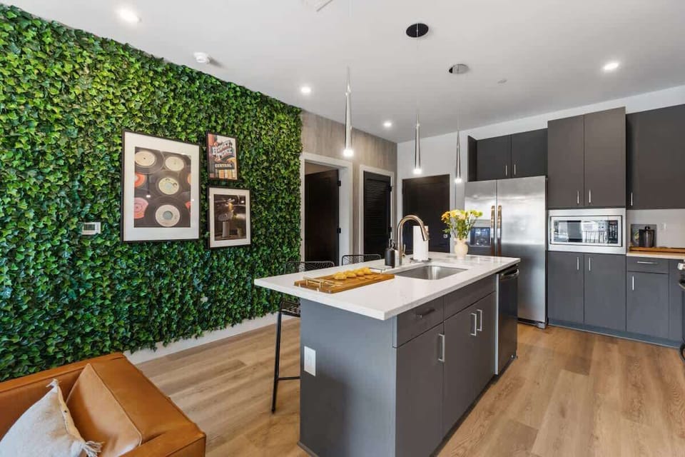 Modern kitchen with a striking green accent wall and a central island.