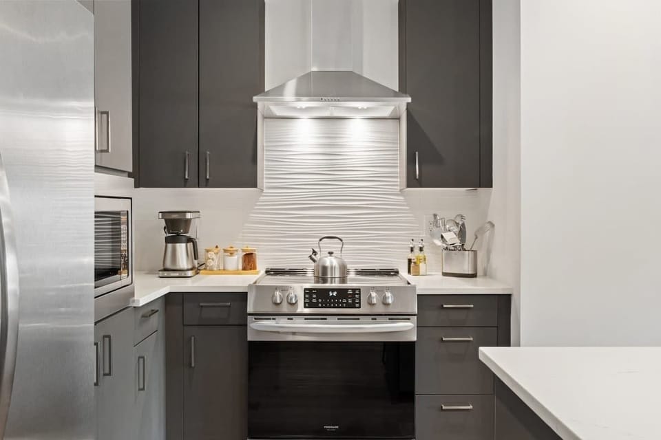 High-end kitchen featuring stainless steel appliances and a sleek, modern range hood.